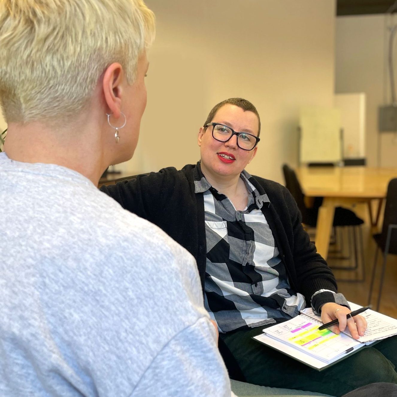 Two humans with short hair having a discussion